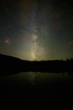 The Milky Way faintly reflects off the still surface of Echo Lake near Mt. Evans, Colorado.